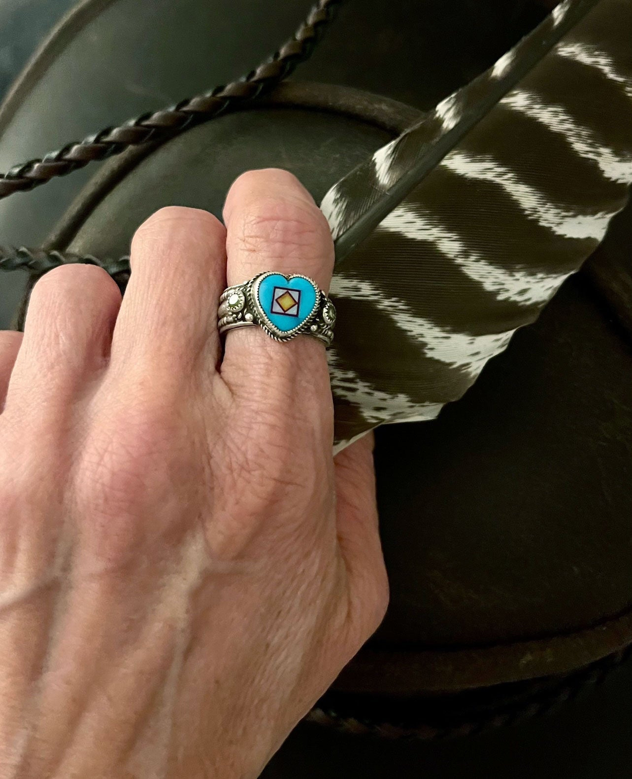 turquoise heart inlay ring by aldrich art jewelry on a woman's pointer finger