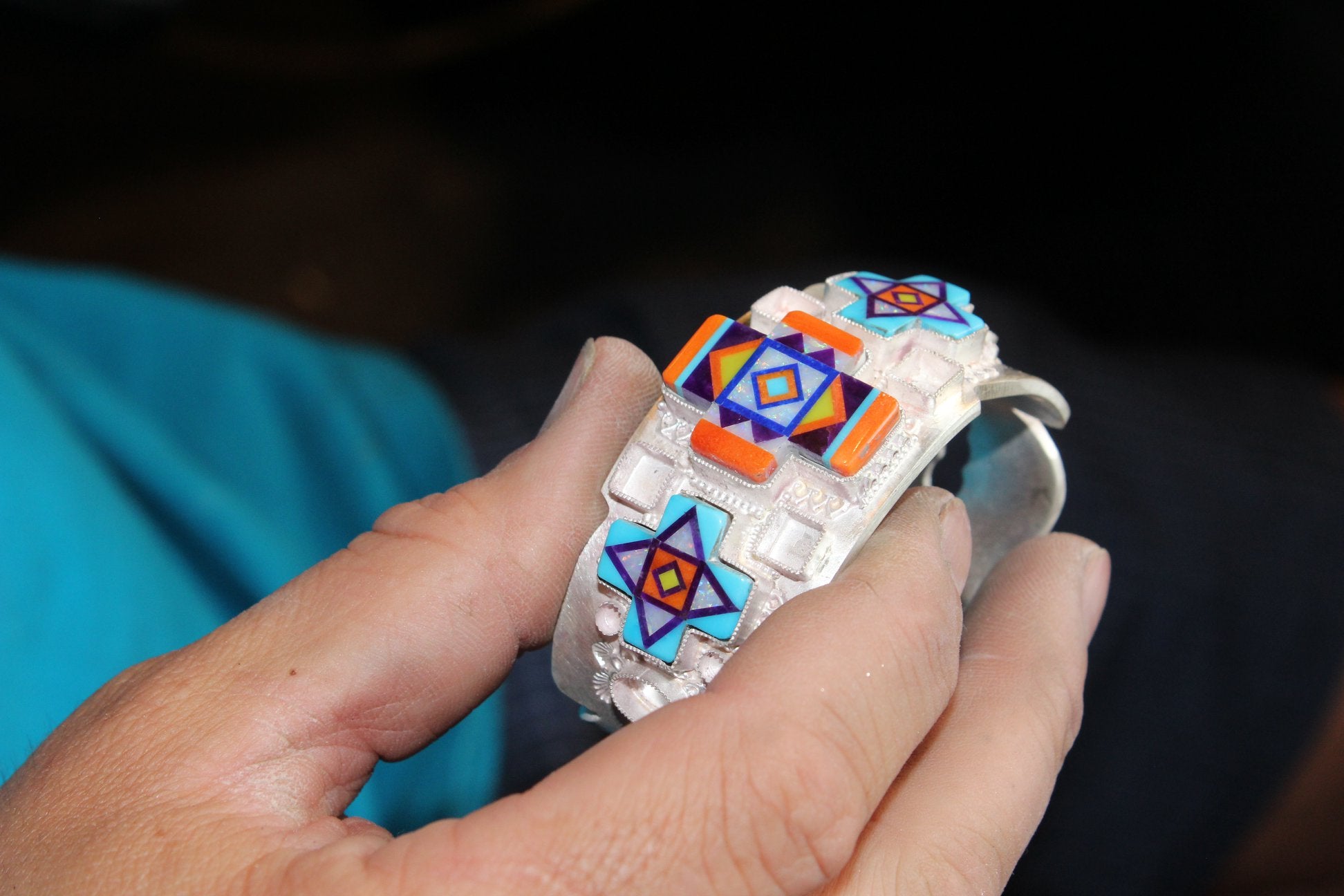 Cast silver cuff bracelet with intarsia inlay crosses being fit into their bezels